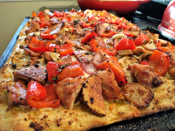 Pizza with olive oil, mozzarella, grilled chicken, roasted potatoes and red peppers
