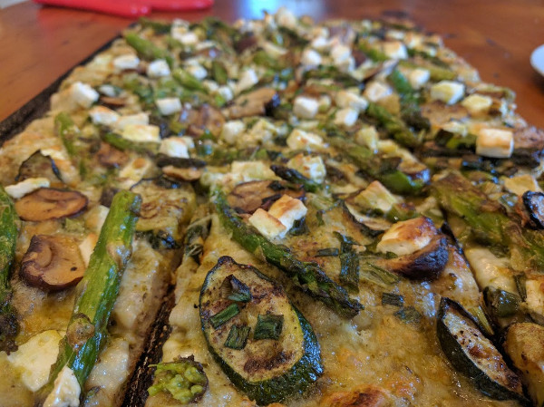 Pesto pizza with bocconcini, feta, green onions and roasted zucchini, asparagus and mushroom
