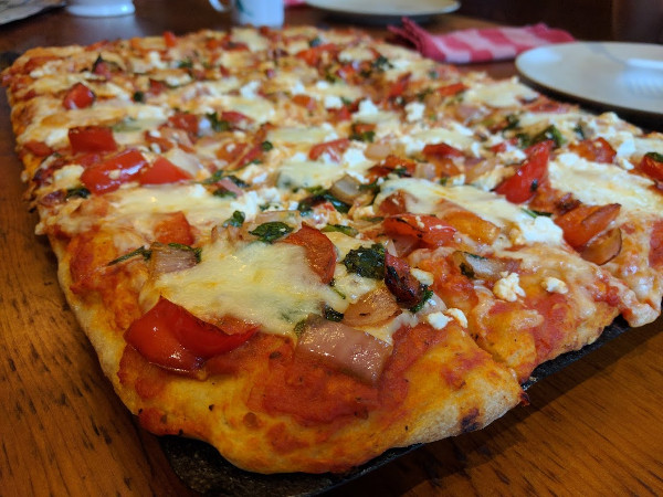 Pizza with tomatoes, onions, peppers and basil