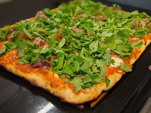 Pizza with prosciutto and arugula