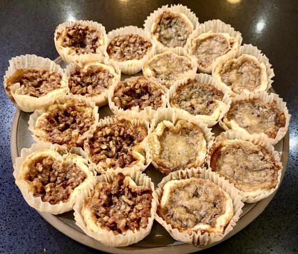 Pecan (left) and raisin (right) butter tarts on a platter Pecan (left) and raisin (right) butter tarts on a platter