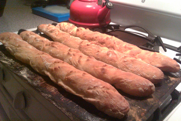 Four cooked baguettes, at least one of which actually looks like a baguette